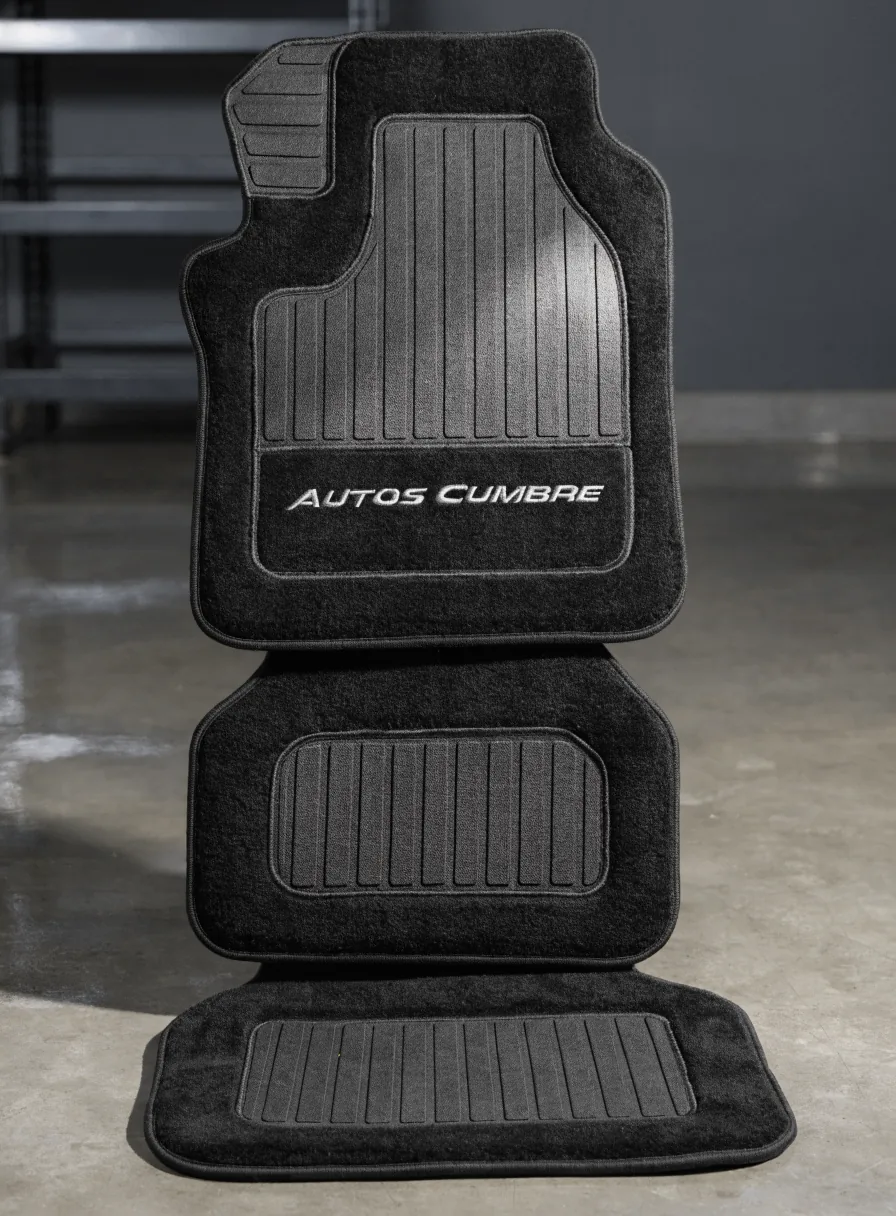 juego de tapetes negros para auto bordados Autos Cumbre en hilo plata, apilados en el piso de la agencia