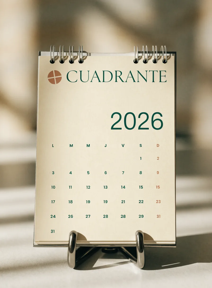 calendario de escritorio de espiral de la marca CUADRANTE con el año 2026 y la cuadrícula del mes impresa en verde, sobre un caballete metálico