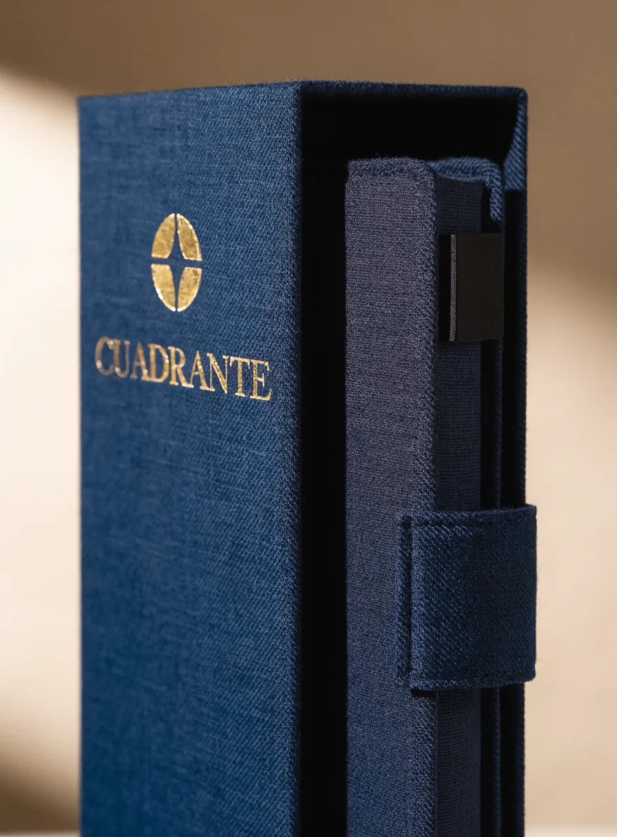 cuaderno de tapa dura entelada en azul marino de la marca CUADRANTE dentro de su estuche de tela a juego con presilla para pluma y el nombre en foil dorado