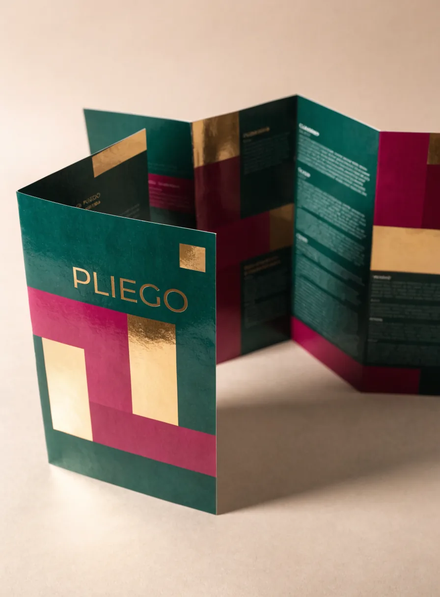 tríptico corporativo de la marca ficticia PLIEGO desplegado en acordeón, con bloques de color verde, magenta y foil dorado y columnas de texto en los paneles interiores