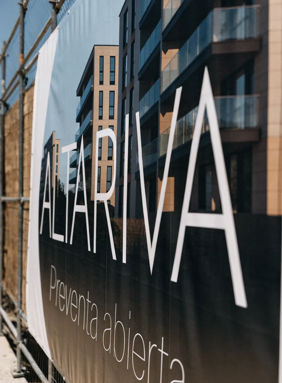 lona de gran formato ALTARIVA con la leyenda Preventa abierta, instalada en la valla de la obra frente al edificio en construcción