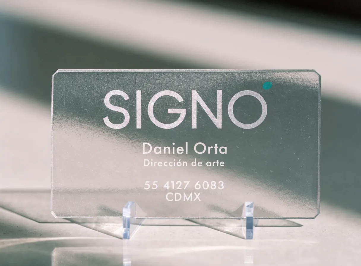 una tarjeta transparente de PVC esmerilado de la marca ficticia SIGNO con el nombre impreso en blanco y un punto de color