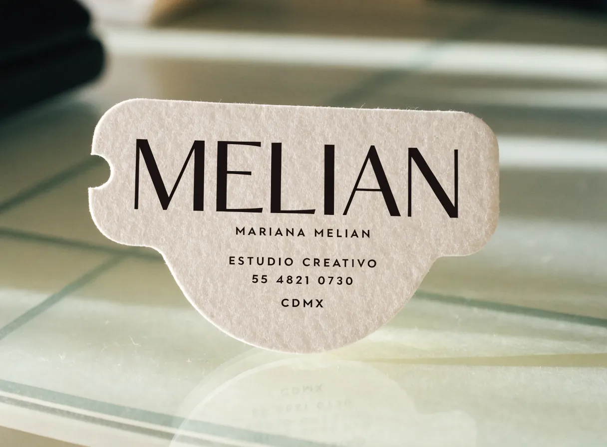 tarjeta de presentación suajada con una silueta troquelada y una pestaña lateral, en papel texturizado, con la marca ficticia Melián, Estudio Creativo, CDMX