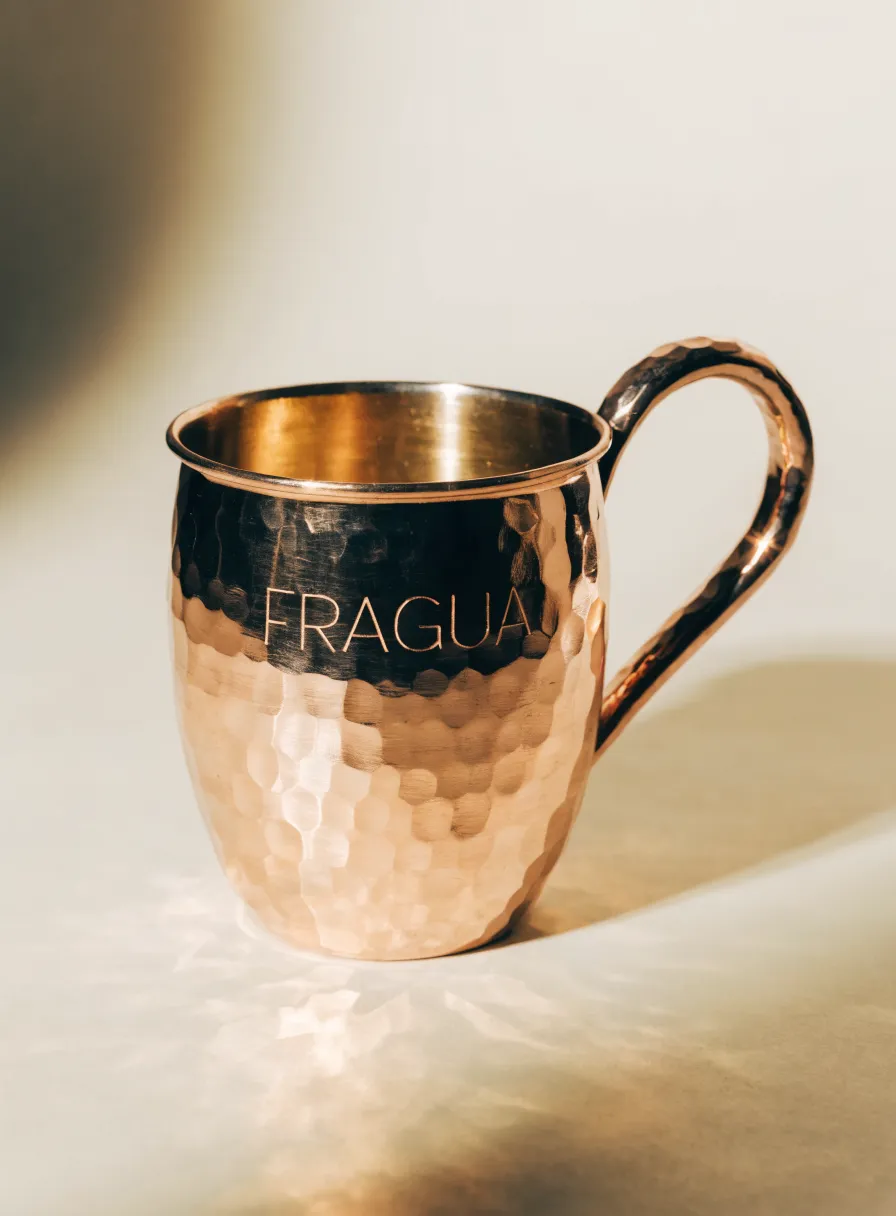 tarro de cobre martillado a mano con la marca ficticia Fragua grabada y el interior pulido