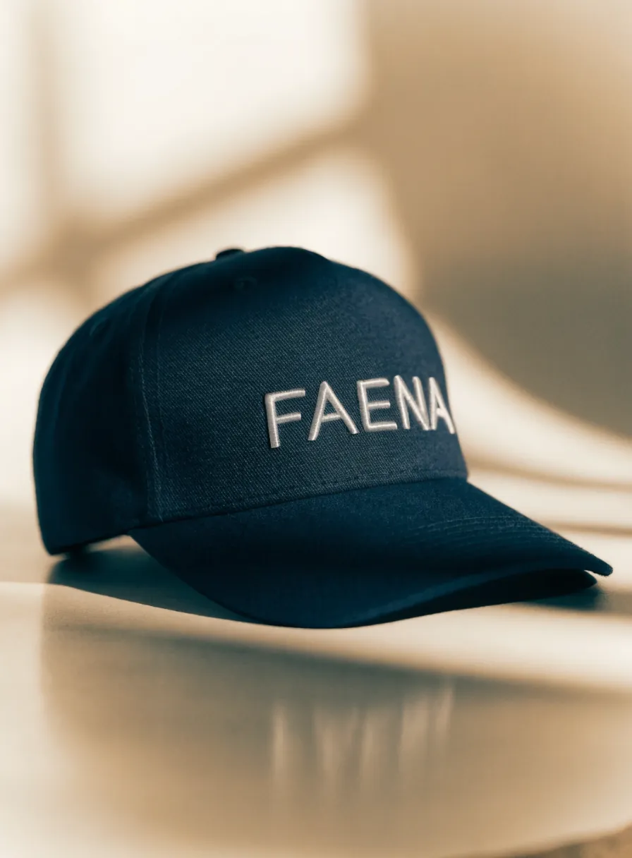 gorra estructurada azul marino con la palabra FAENA bordada en hilo blanco al frente