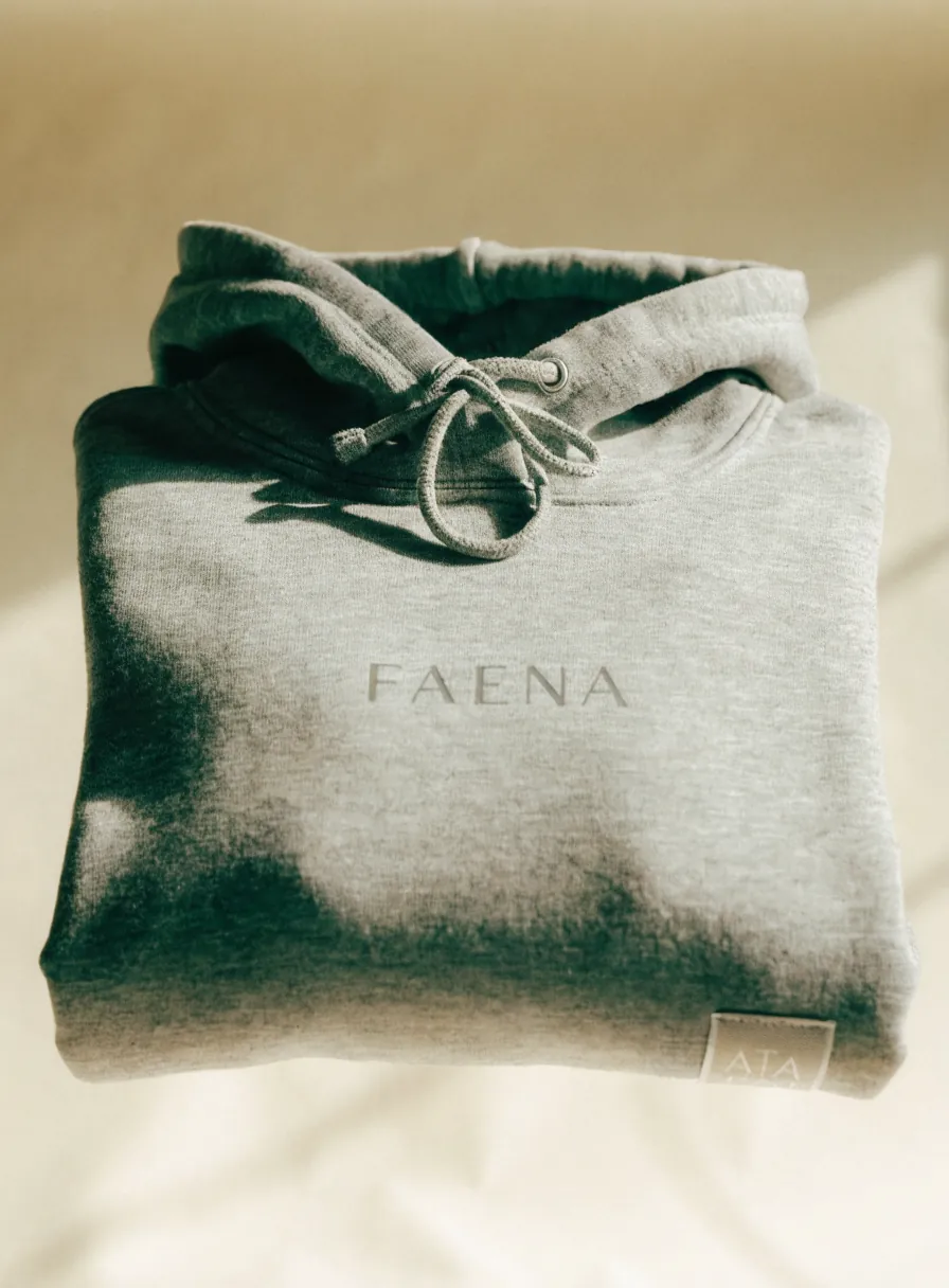sudadera con capucha en gris jaspeado con la marca FAENA estampada tono sobre tono al frente