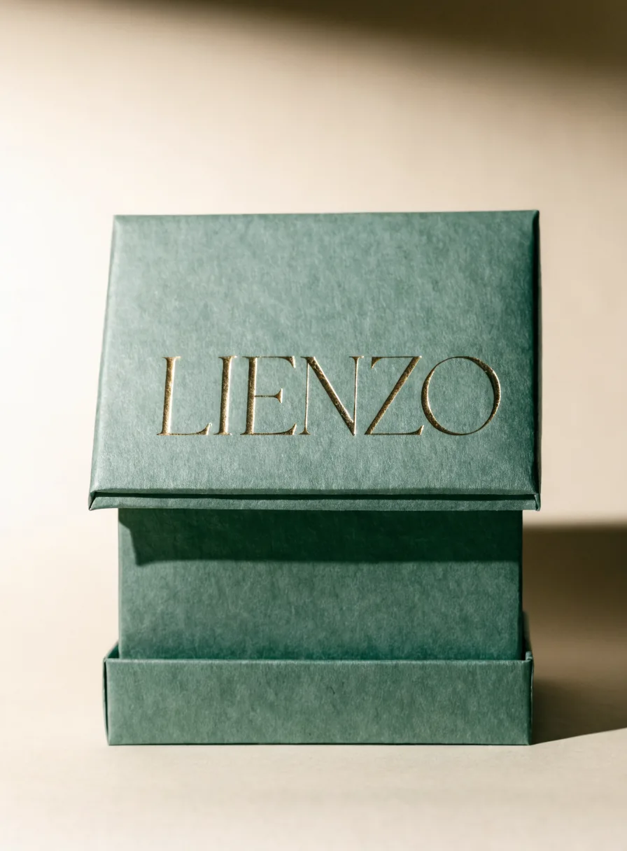 estuche de cartón verde salvia con la palabra LIENZO en foil de oro hundida a registro sobre la tapa