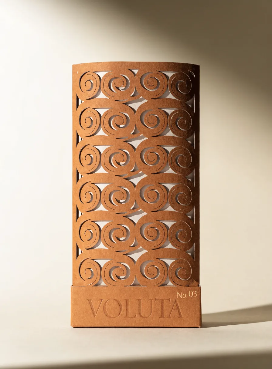 estuche kraft numerado No 03 de la marca Voluta, con un patrón de espirales calado a láser sobre un forro interior claro y el nombre en relieve ciego