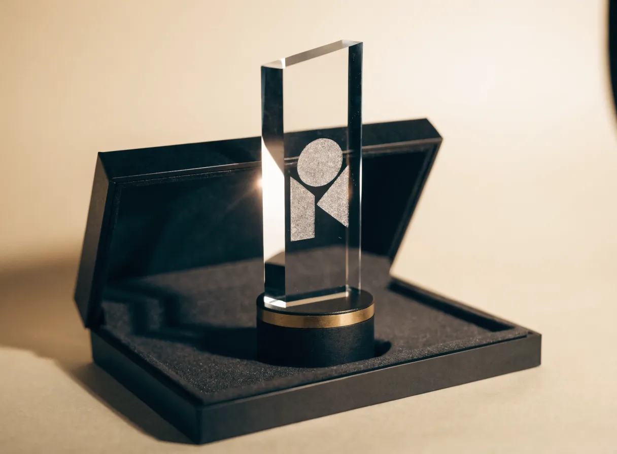 reconocimiento de cristal grabado sobre una base negra con detalles en oro, dentro de su estuche