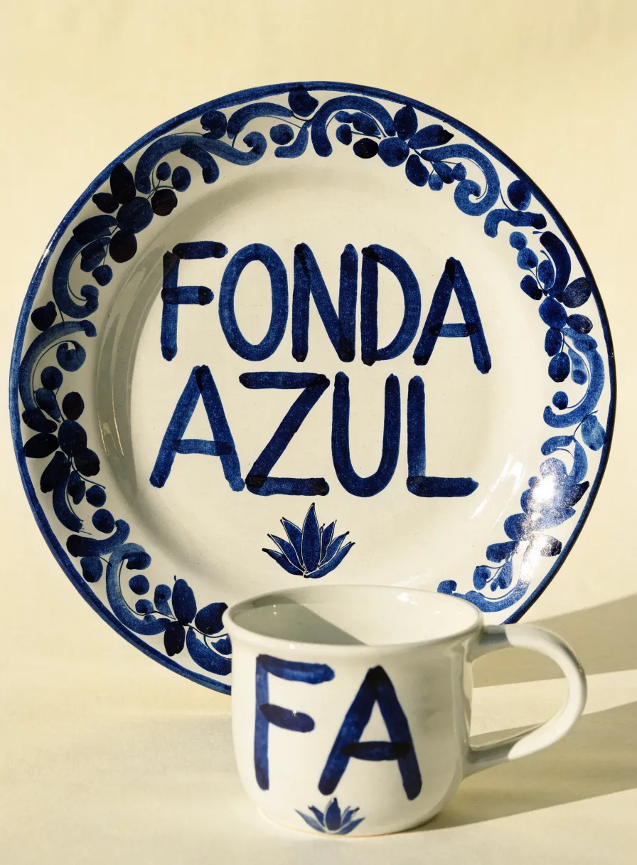 Plato de talavera pintado a mano con la leyenda Fonda Azul en azul cobalto y un motivo de agave, con una taza a juego