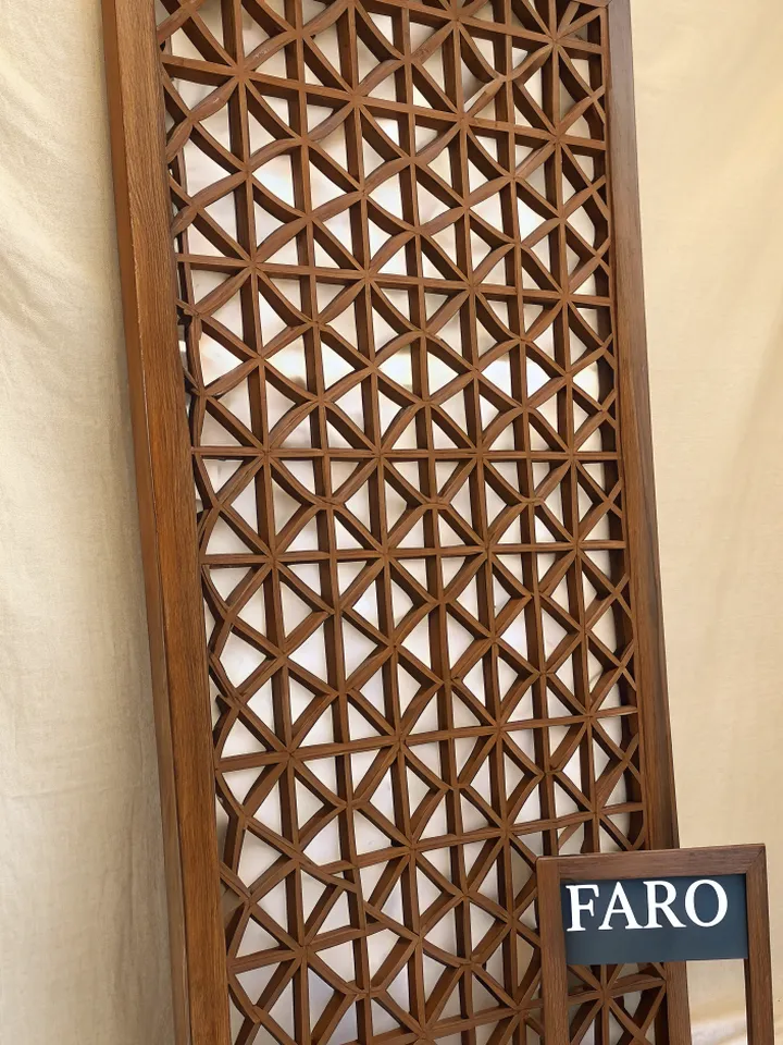 letrero de fachada con letras de madera y una celosía calada detrás