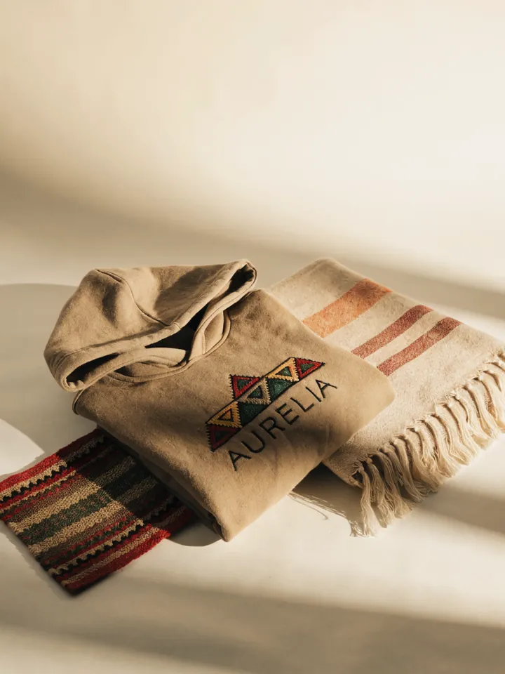 un rebozo tejido en telar con rayas de colores y una prenda de punto, en fibras naturales