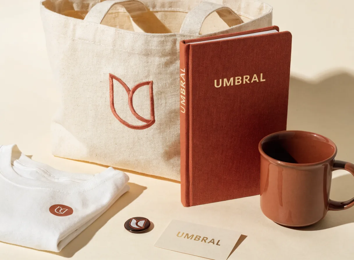 kit de bienvenida con tote de lona, cuaderno entelado, taza y gafete, todo con la marca Umbral bordada y grabada