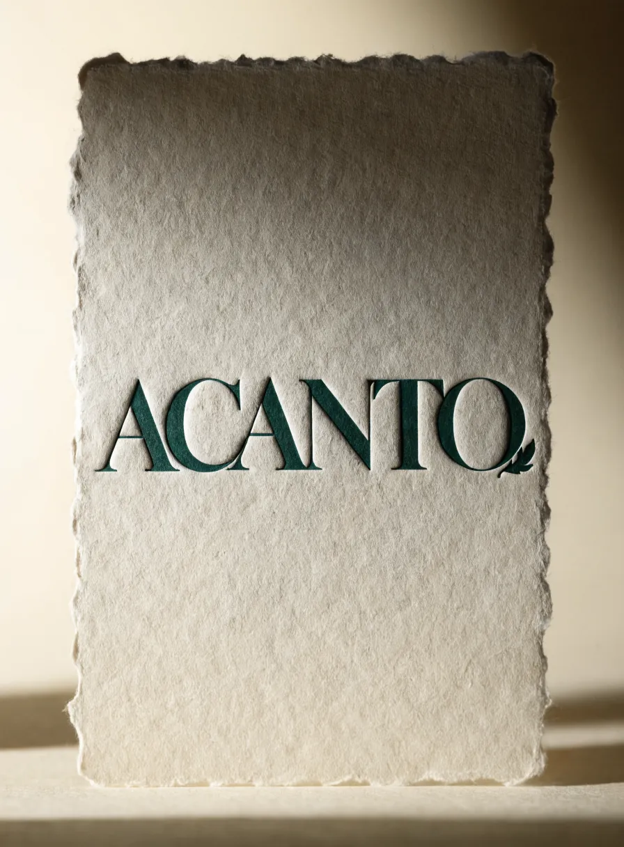 tarjeta de papel de algodón con borde deshilachado, la palabra ACANTO impresa en letterpress verde profundo hundido en la fibra