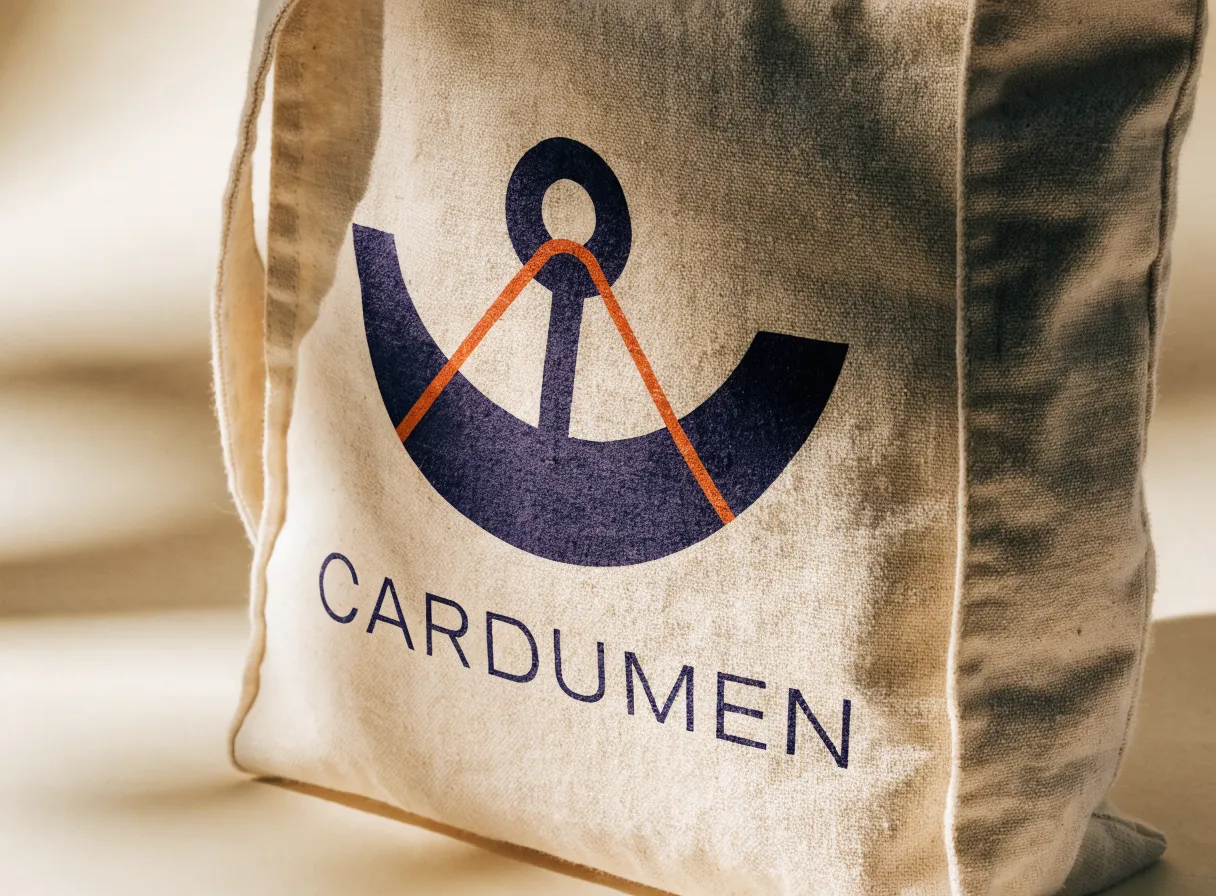 acercamiento a un tote de algodón con el ancla y el trazo naranja de la marca CARDUMEN serigrafiados en grande y la palabra CARDUMEN debajo