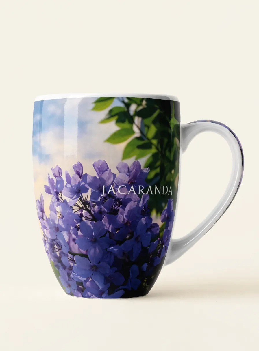 taza de cerámica blanca con un wrap de jacarandas moradas sublimado de orilla a orilla
