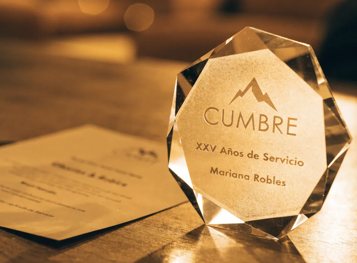 reconocimiento octagonal de cristal grabado con la marca Cumbre, XXV Años de Servicio y el nombre de Mariana Robles, junto a su certificado