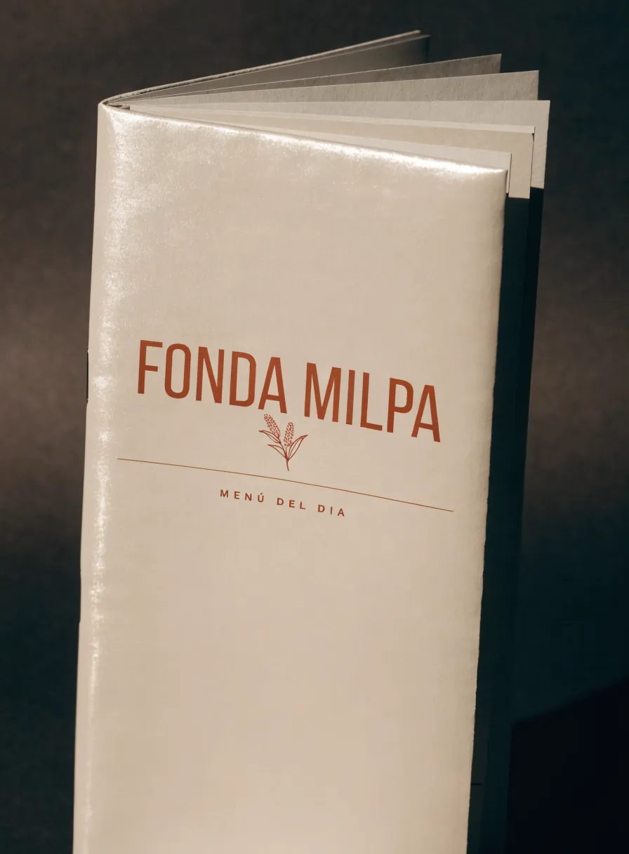 menú del día laminado a color, carta bifold sobre superficie crema