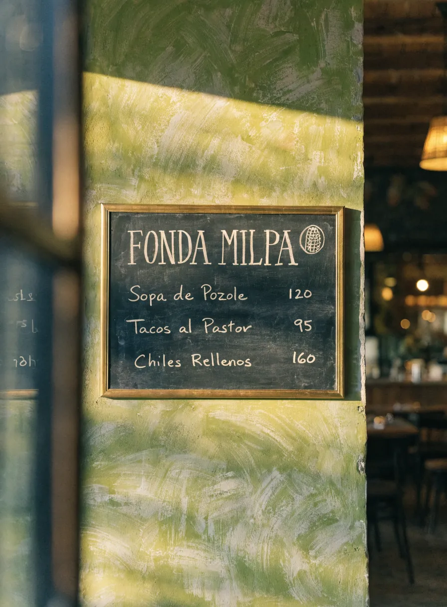 menú de pizarrón de pared con la lista del día escrita a mano y la marca Fonda Milpa