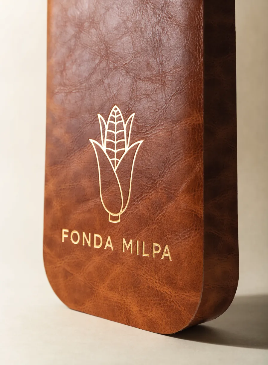 portamenú de piel cognac con el sello Fonda Milpa estampado en foil dorado