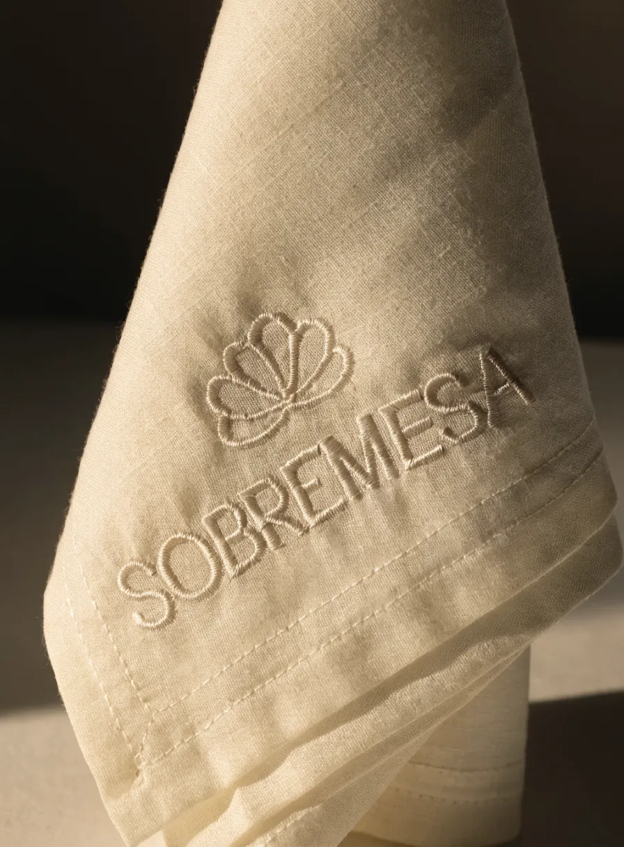 servilleta de algodón marfil con emblema bordado en satin-stitch
