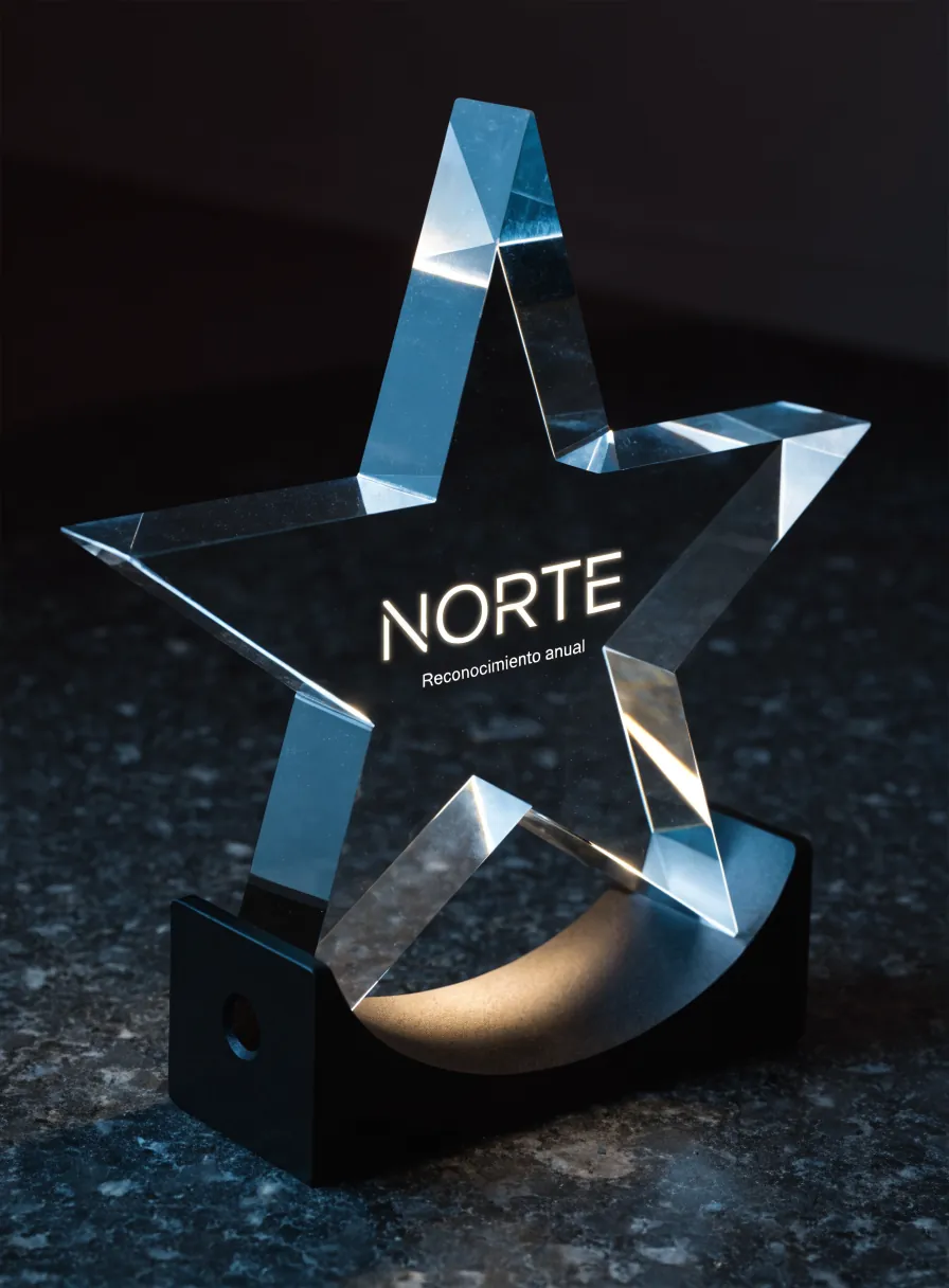 estrella de cinco puntas cortada en cristal macizo, apoyada en una cuna de metal negro con luz oculta, grabada con la palabra Norte