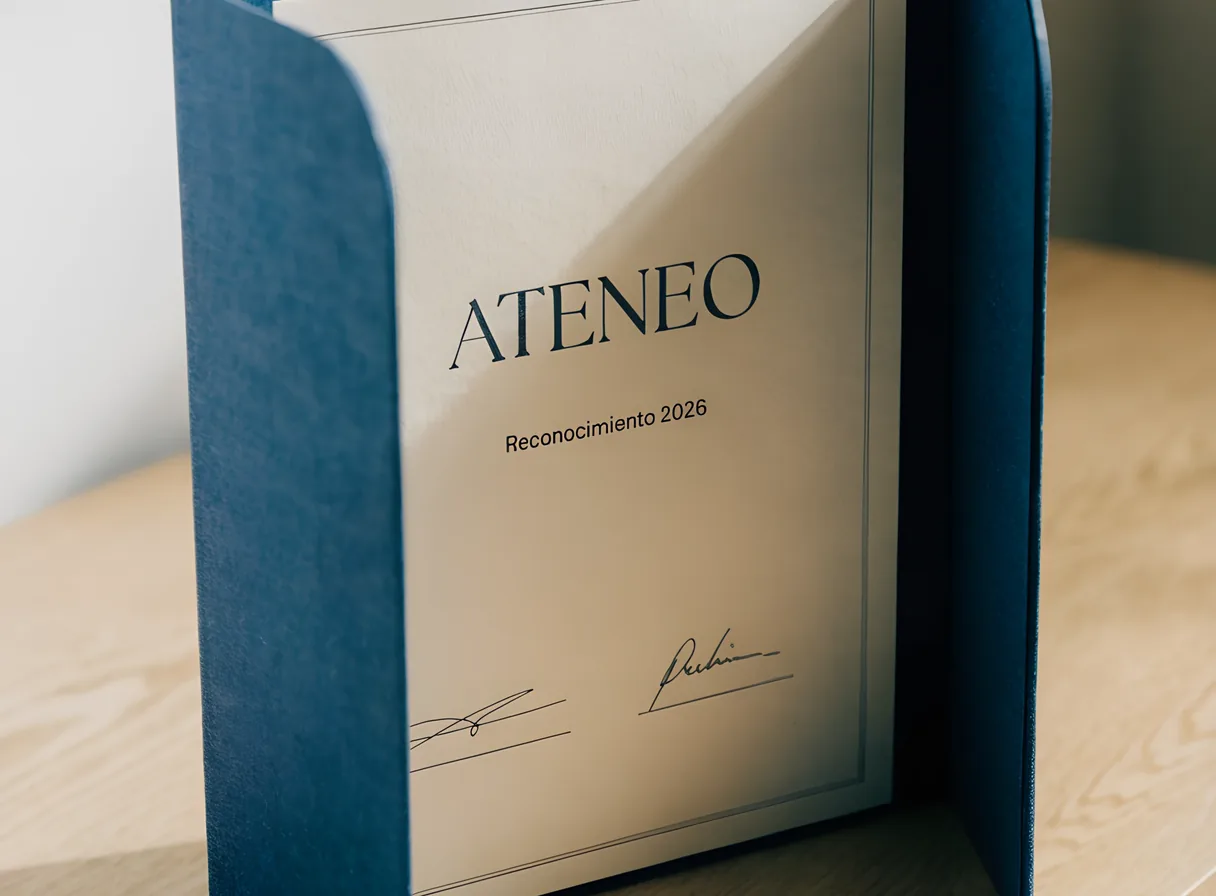 diploma impreso en papel de certificado color marfil con la palabra Ateneo y dos firmas, de pie dentro de su carpeta de tela azul